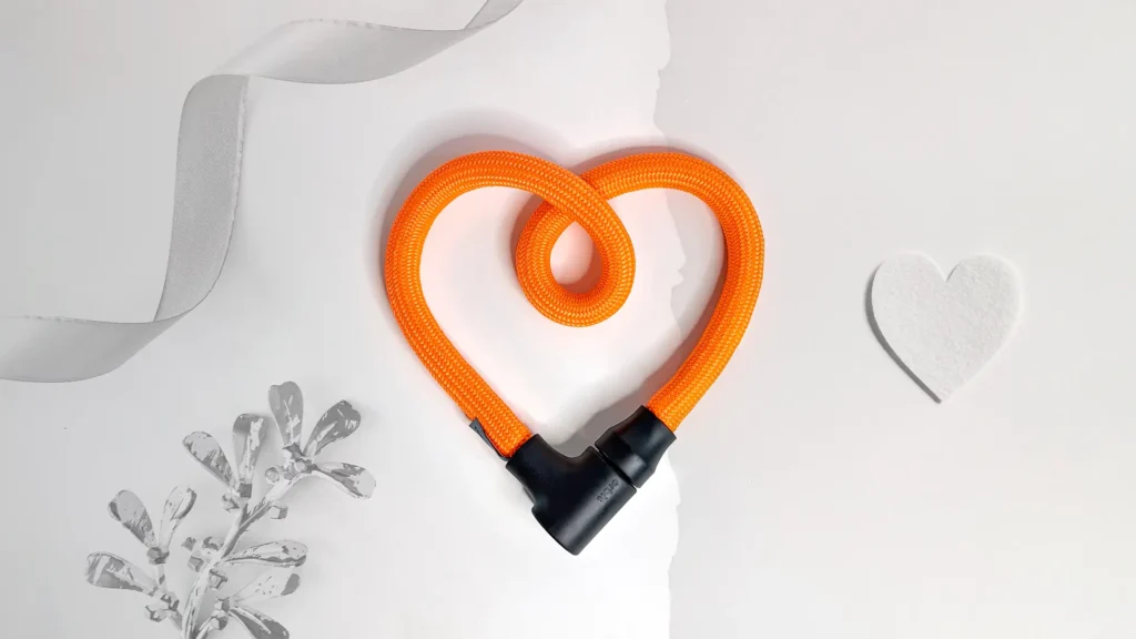 texlock orbit in acid orange als Herz geformt vor weißem Hintergrund