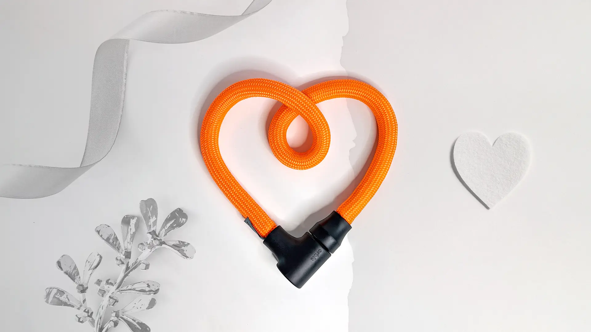 texlock orbit in acid orange als Herz geformt vor weißem Hintergrund